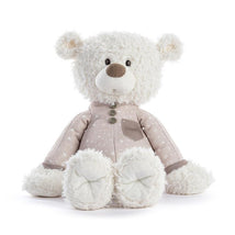 Stuffed bear wearing a beige pajamas with a star pattern, featuring a soft, fluffy texture in brown and white.