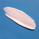 A smooth, creamy layer of diaper rash cream on a blue background, highlighting its soothing texture for babies.