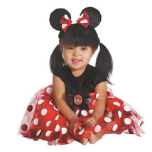 Toddler wearing a red Minnie Mouse costume with polka dots, black top, and mouse ears, smiling while sitting.