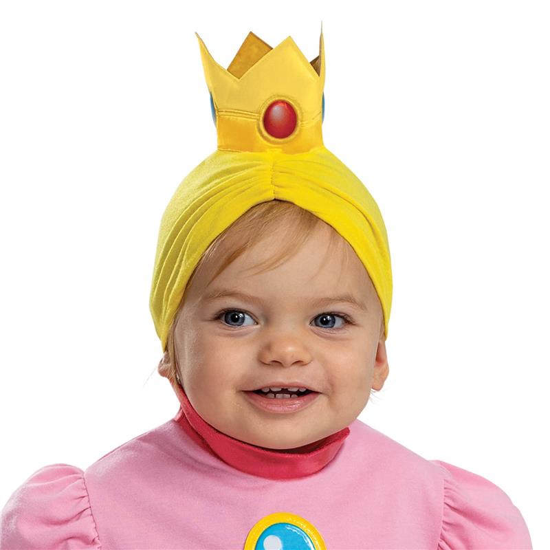 Infant wearing a pink dress with puffy sleeves and a yellow crown headband, smiling and showcasing the Princess Peach costume.