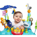 Baby smiling while seated in a colorful Disney Baby Finding Nemo jumper with various sea-themed toys.