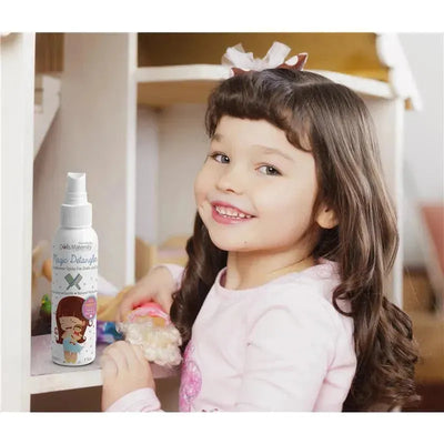 Reborn Baby Dolls Magic Detangler Conditioner Spray for Dolls displayed on a shelf, with a smiling girl holding a doll.