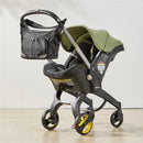 Essentials bag in Nitro Black attached to a Doona stroller with a green canopy and padded seat.