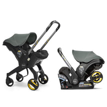 Infant car seat with base in slate green, featuring a sturdy frame, canopies, and visible safety labels.