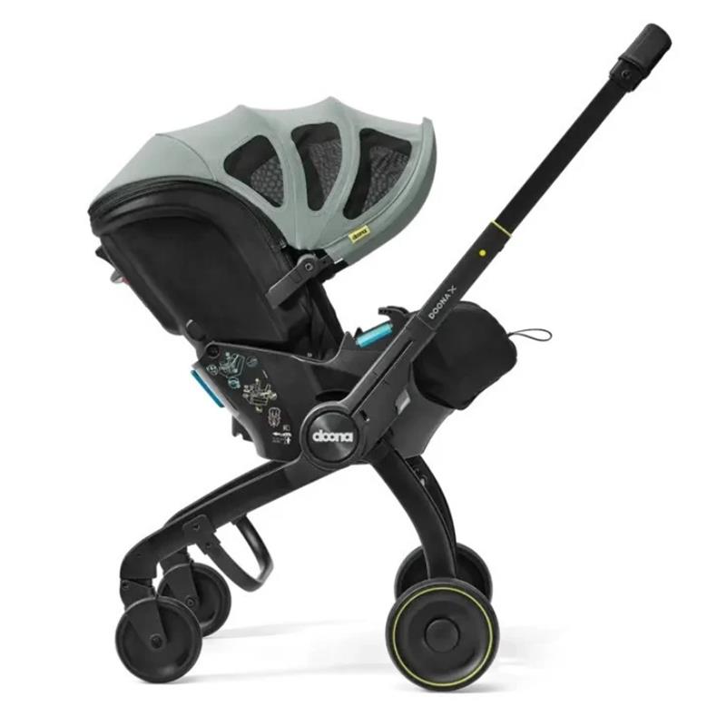 Doona X Summer Canopy in Dusty Sage, featuring a sleek infant car seat with a protective canopy and stroller wheels.