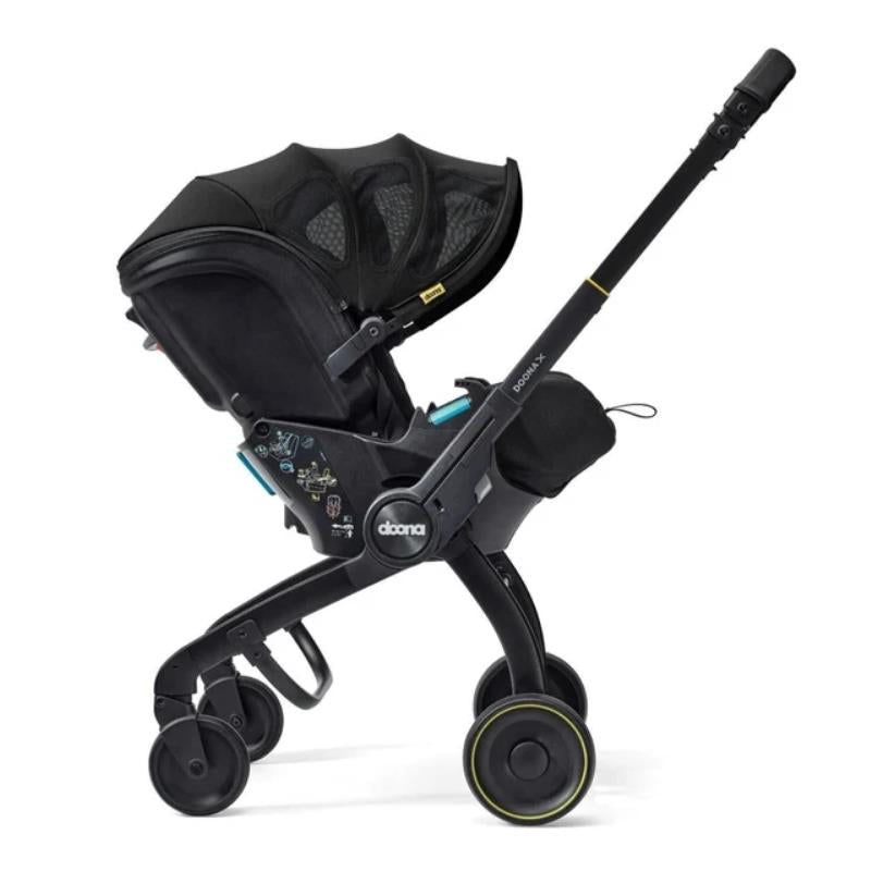 Doona X Summer Canopy in Nitro Black, featuring a sleek design, adjustable canopy, and attached child safety seat.