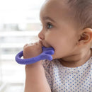Baby chewing on a purple octopus-shaped teether, wearing a polka-dot shirt, with soft natural light in the background.