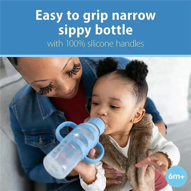 Light blue narrow sippy bottle with silicone handles. A child is drinking from it while being held by a caregiver.