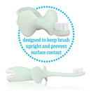 Mint elephant-shaped training toothbrush designed to keep brush upright, with text about preventing surface contact.