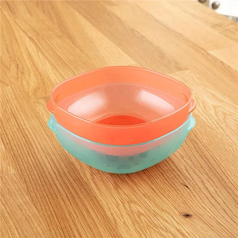 Two nesting bowls from Dr. Brown, one turquoise with a soft grip and one orange, displayed on a wooden surface.