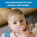 Baby with blue eyes holding a pink pacifier in their mouth, featuring a loop attachment for secure fit.