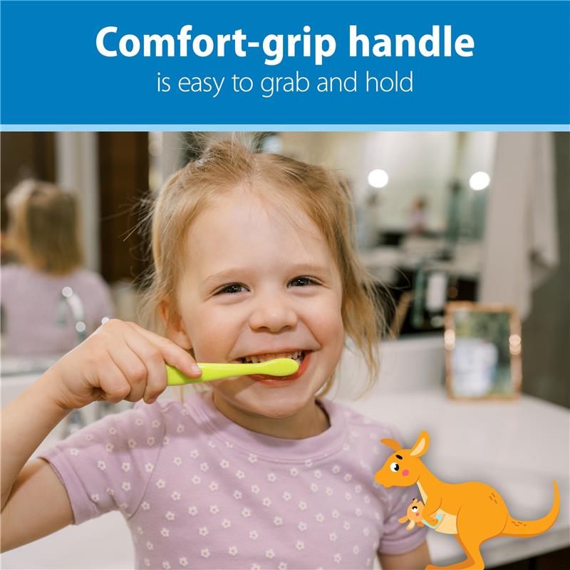 Young child smiling while brushing teeth with a green toothbrush, highlighting its comfort-grip handle.