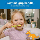 Young child smiling while brushing teeth with a green toothbrush, highlighting its comfort-grip handle.