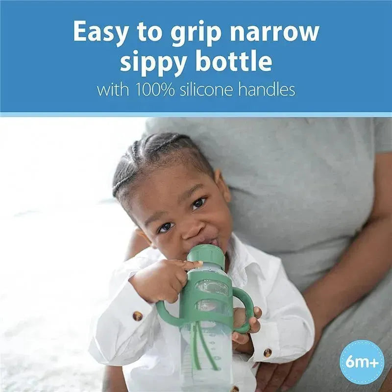 Narrow green sippy bottle with silicone handles held by a toddler, featuring text about being easy to grip and suitable for ages 6 months and up.