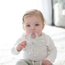 Gray Flexees Bunny Silicone Teether held by a baby sitting on a soft surface, featuring a rabbit design with textured handles.