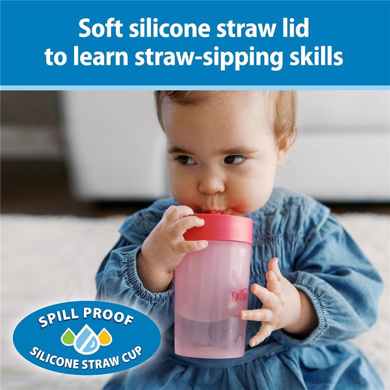 Pink coral training cup with soft silicone straw, held by a toddler learning to sip, labeled as spill-proof.