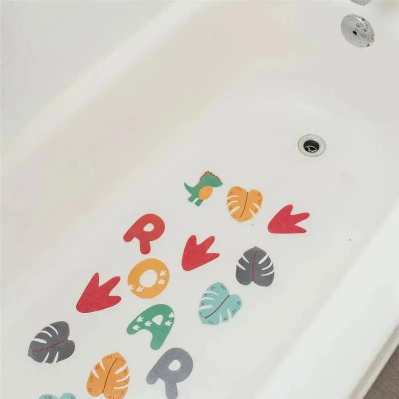 Colorful non-slip bath stickers shaped like leaves and dinosaur footprints on a white bathtub surface.