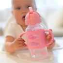 Wide-neck pink sippy straw bottle with silicone handles, being held by a child in a highchair.