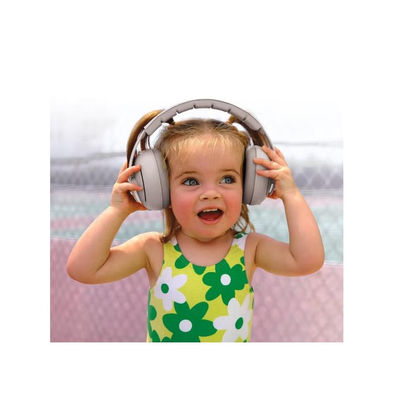 Toddler wearing oversized light grey earmuffs and a colorful floral swimsuit, smiling happily.