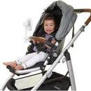 A smiling toddler sitting in a stroller with a gray canopy and a white clip-on fan.