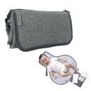 Change mat in charcoal with a baby lying on it, featuring storage pockets and a soft, padded surface.
