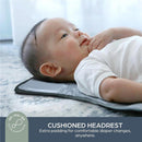 Change mat in charcoal color with a cushioned headrest, featuring a baby lying comfortably during a diaper change.