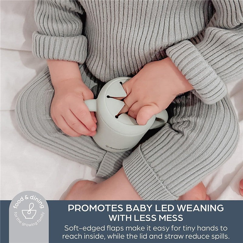Seafoam Dreambaby Drink & Snack Cup held by a child in soft grey clothing, designed for mess-free baby-led weaning.