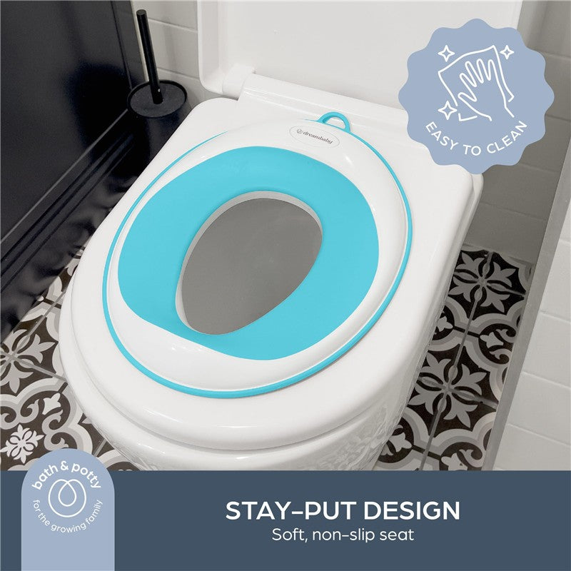 Aqua Dreambaby potty trainer seat features a soft, non-slip design, displayed on a toilet with a decorative floor.