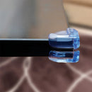 Clear corner cushions protecting glass table edges, designed to enhance safety for children and prevent injuries.