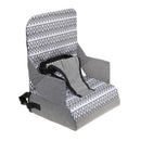 Booster seat featuring a zigzag grey design, with a harness for safety and designed for easy portability.