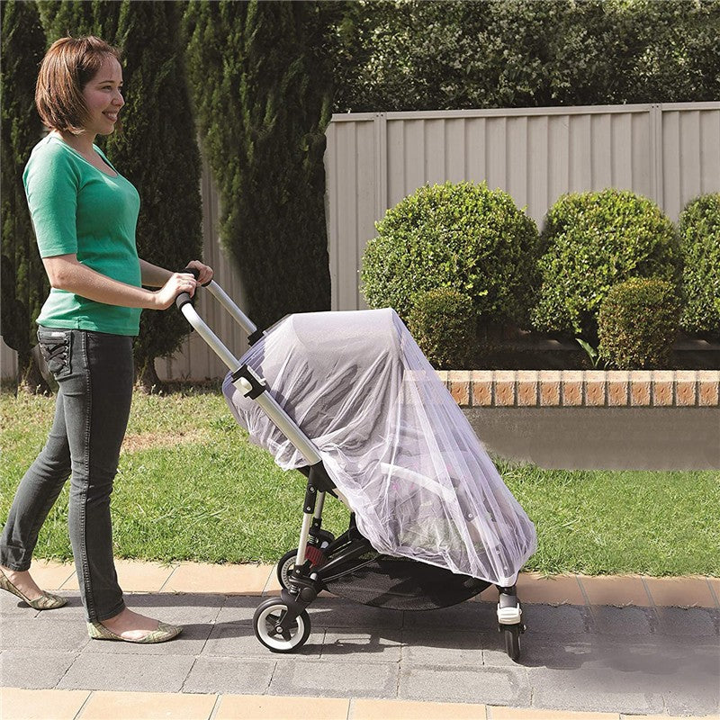 Dreambaby Stroller Insect Netting covers a stroller pushed by a woman in a green shirt, protecting it from insects.