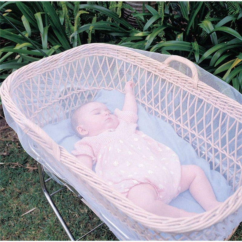 Insect netting covers a baby sleeping in a wicker bassinet, showcasing safety for outdoor use.
