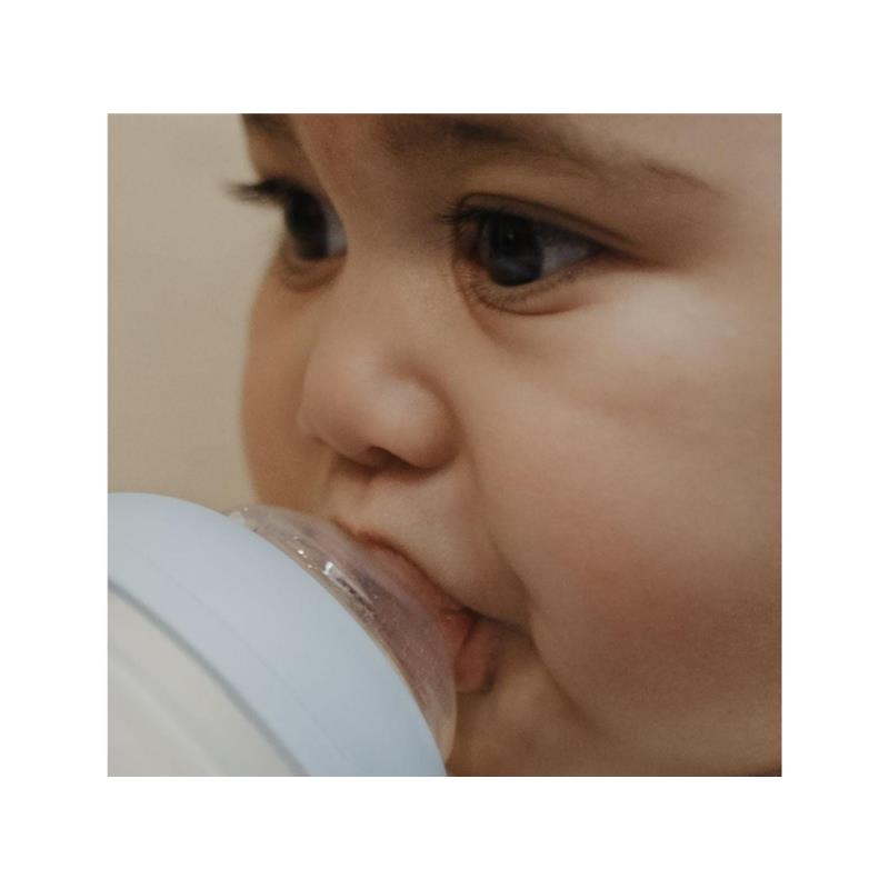 A baby with a close-up view, drinking from a light blue Elhee Full Of Love 8 oz baby bottle.