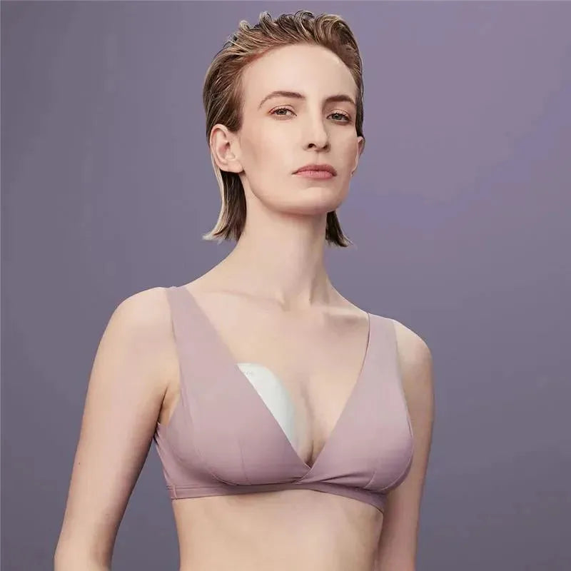 Single Smart Wearable Electric Breast Pump by Elvie, worn by a woman in a mauve bra, showcasing discreet use.