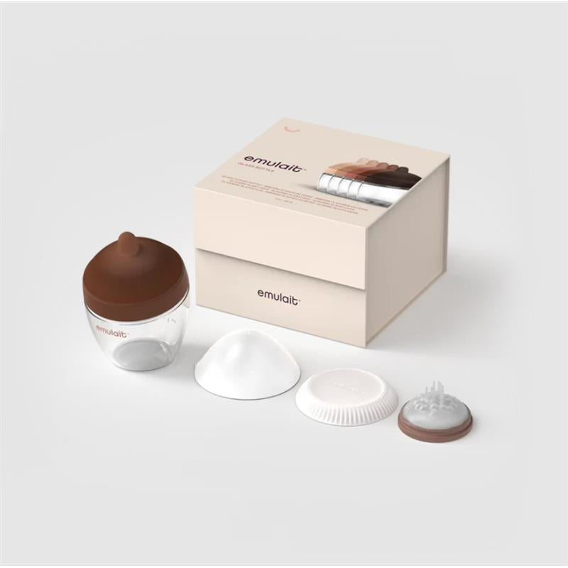 Emulait glass bottle with a brown nipple, accompanied by four interchangeable nipple shapes and a cream-colored box.
