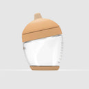 Glass classic baby bottle with a light brown nipple, featuring measurement markings on the side.