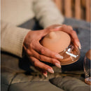 Emulait medium bottle nipple with a soft silicone top, held by a person against a textured surface.