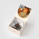 An Emulait Anatomy Bottle with medium nipple color and shape 1, displayed in an open box alongside additional components.