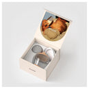 Classic bottle nipple set from Emulait, featuring a clear bottle, multiple nipple shapes, and a baby drinking.