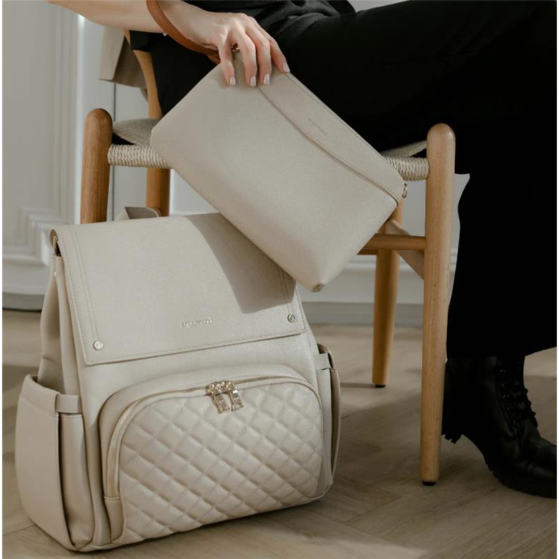 Light beige Enya Mond Nova Bag with a quilted front pocket, accompanied by a smaller matching pouch held by a person.