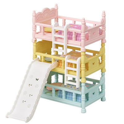 Triple bunk beds set in pastel colors with a slide, featuring patterned bedding and ladders for access.