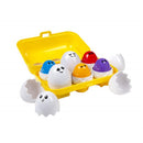 Colorful baby match-up toy featuring bright egg-shaped figures with faces in a yellow carrying case, promoting play with lights and music.
