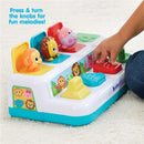 Colorful toy featuring animal figures and knobs, labeled with “Press & turn the knobs for fun melodies!”