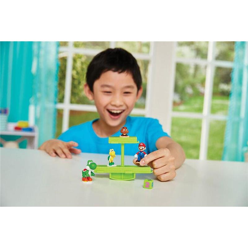 Young boy joyfully plays with the Epoch Super Mario Balancing Game, featuring Mario, Yoshi, Goomba, and a balancing platform.