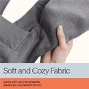 Gray ergonomic baby carrier fabric held by a hand, highlighting its soft knit texture and newborn-friendly details.
