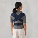Ergobaby Embrace Newborn Baby Carrier shown worn on a woman, featuring crossed shoulder straps and a secure waist belt.