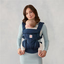 Ergobaby Omni Classic Baby Carrier in Midnight Blue worn by a woman with a baby facing inward.