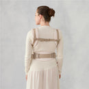 Ergobaby Omni Classic Baby Carrier in natural beige, worn by a woman, showing adjustable straps and back support.