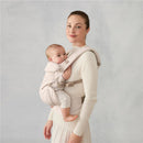 Ergobaby Omni Classic Baby Carrier in natural beige, supporting a baby in a front carry position with a smiling mother.