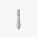 Sage-colored Baby-Led™ toothbrush designed for infants, featuring a textured grip and soft bristles for gentle cleaning.